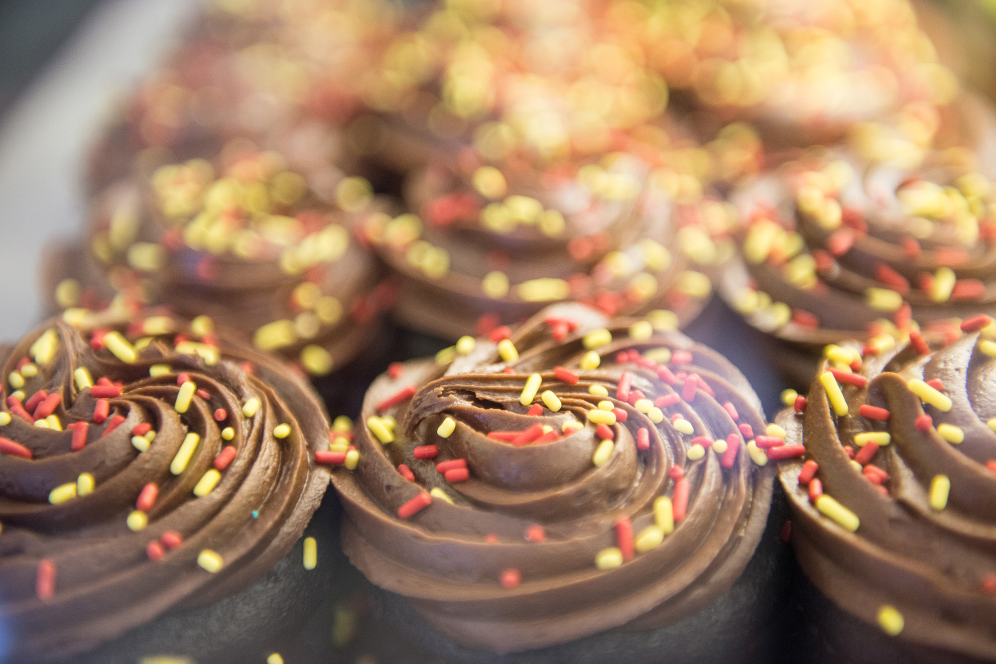 Chocolate Cupcakes with chocolate frosting and orange/yellow sprinkles