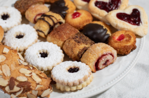 Platter filled with sweet treats (jam-filled cookies, jam pinwheels, chocolate-covered pastry and more sweets